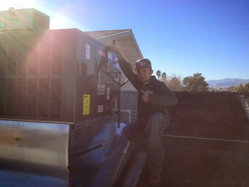 HVAC technician performing Heat Pump Repair on a rooftop unit in Surf City